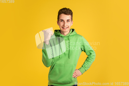 Image of Portrait of young caucasian man isolated on yellow studio background