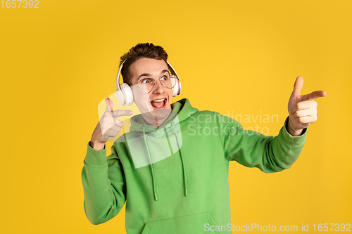 Image of Portrait of young caucasian man isolated on yellow studio background