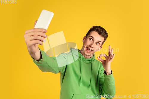 Image of Portrait of young caucasian man isolated on yellow studio background