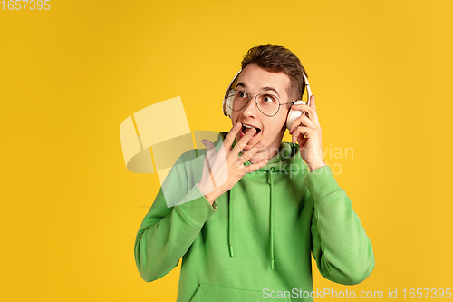 Image of Portrait of young caucasian man isolated on yellow studio background