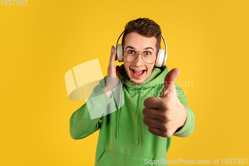 Image of Portrait of young caucasian man isolated on yellow studio background