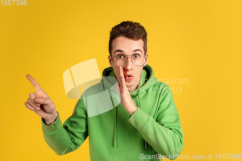 Image of Portrait of young caucasian man isolated on yellow studio background