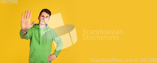 Image of Portrait of young caucasian man isolated on yellow studio background