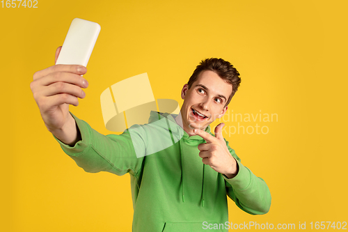 Image of Portrait of young caucasian man isolated on yellow studio background