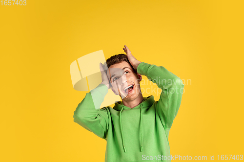 Image of Portrait of young caucasian man isolated on yellow studio background