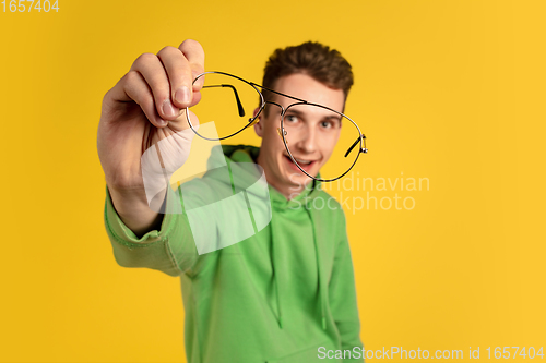 Image of Portrait of young caucasian man isolated on yellow studio background