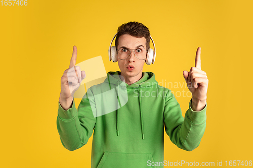 Image of Portrait of young caucasian man isolated on yellow studio background