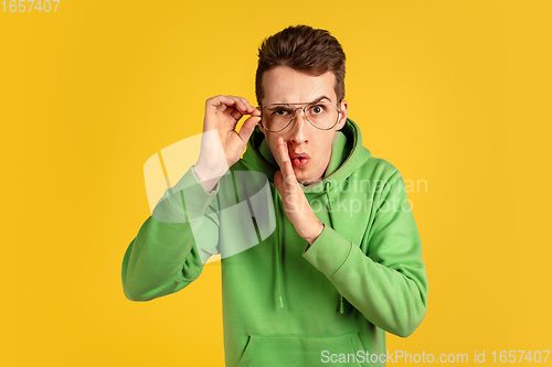 Image of Portrait of young caucasian man isolated on yellow studio background