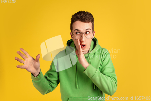 Image of Portrait of young caucasian man isolated on yellow studio background