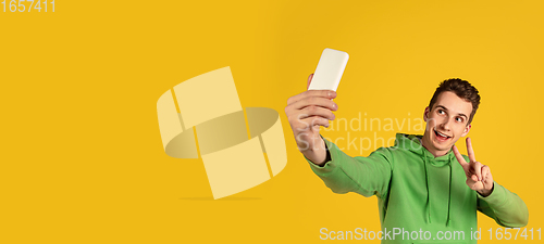Image of Portrait of young caucasian man isolated on yellow studio background