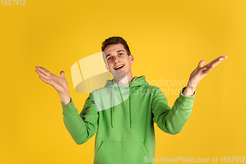 Image of Portrait of young caucasian man isolated on yellow studio background