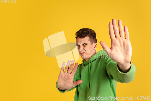 Image of Portrait of young caucasian man isolated on yellow studio background