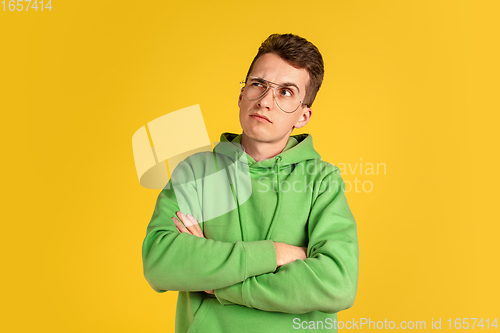 Image of Portrait of young caucasian man isolated on yellow studio background