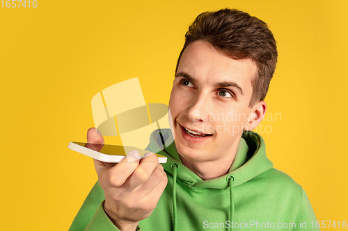 Image of Portrait of young caucasian man isolated on yellow studio background