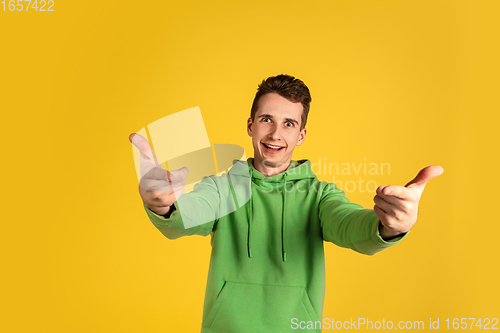 Image of Portrait of young caucasian man isolated on yellow studio background