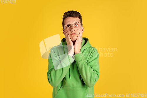 Image of Portrait of young caucasian man isolated on yellow studio background