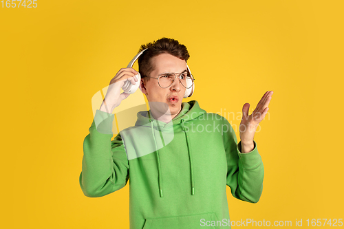 Image of Portrait of young caucasian man isolated on yellow studio background