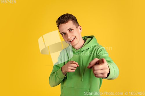 Image of Portrait of young caucasian man isolated on yellow studio background