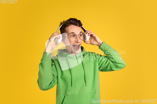 Image of Portrait of young caucasian man isolated on yellow studio background