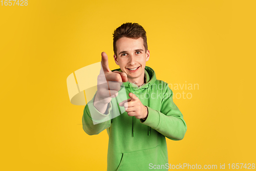 Image of Portrait of young caucasian man isolated on yellow studio background