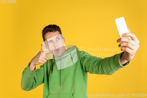 Image of Portrait of young caucasian man isolated on yellow studio background