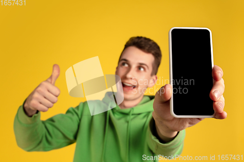 Image of Portrait of young caucasian man isolated on yellow studio background