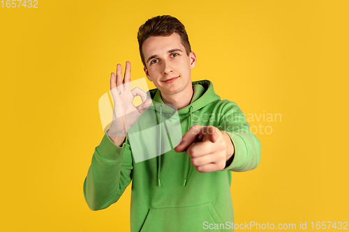 Image of Portrait of young caucasian man isolated on yellow studio background