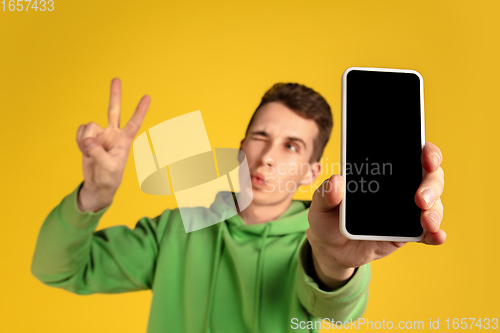 Image of Portrait of young caucasian man isolated on yellow studio background