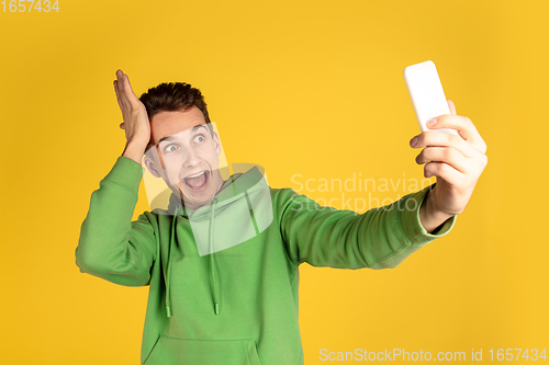 Image of Portrait of young caucasian man isolated on yellow studio background