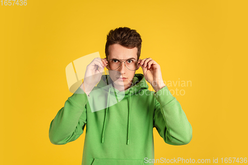 Image of Portrait of young caucasian man isolated on yellow studio background