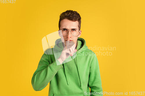 Image of Portrait of young caucasian man isolated on yellow studio background