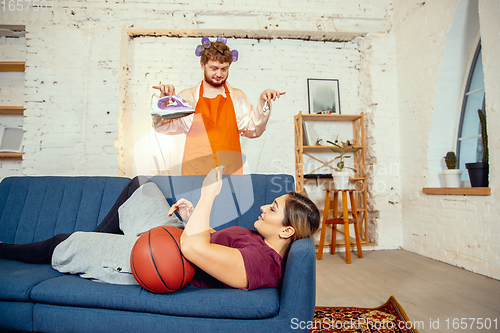 Image of Gender stereotypes. Wife and husband doing things unusual for their genders in social meanings