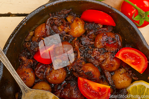 Image of Baby cuttle fish roasted on iron skillet