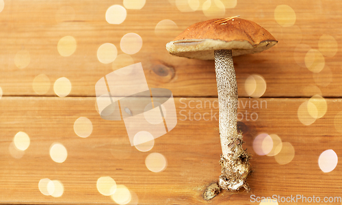 Image of brown cap boletus mushrooms on wooden background