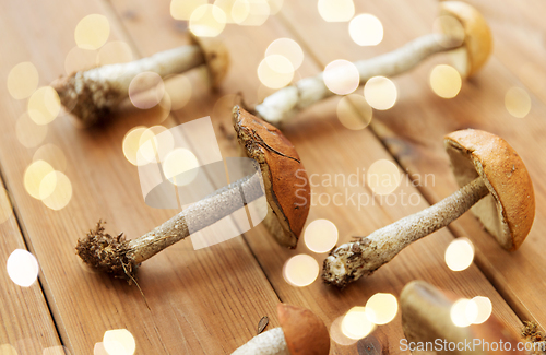 Image of brown cap boletus mushrooms on wooden background