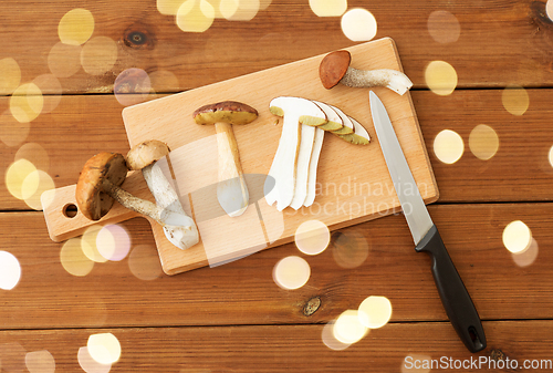 Image of edible mushrooms, kitchen knife and cutting board