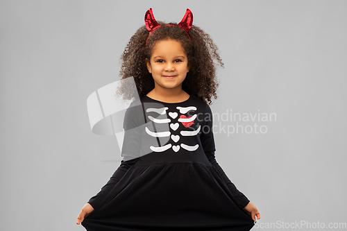 Image of girl in black dress and devil's horns on halloween