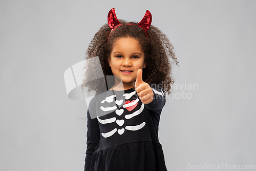 Image of girl in black dress and devil's horns on halloween