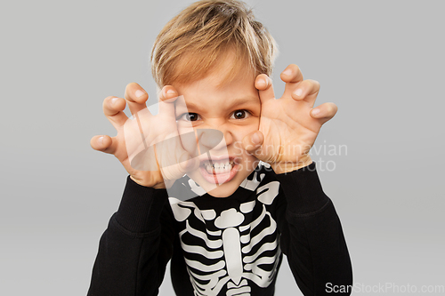 Image of boy in halloween costume of skeleton making faces