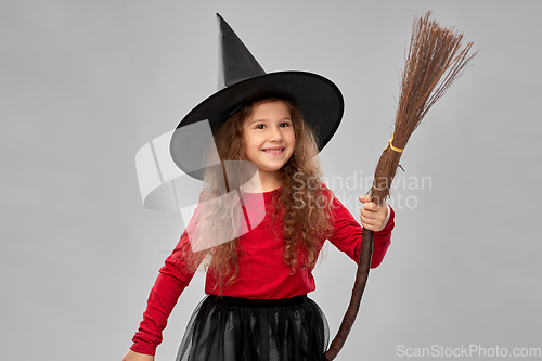 Image of girl in black witch hat with broom on halloween