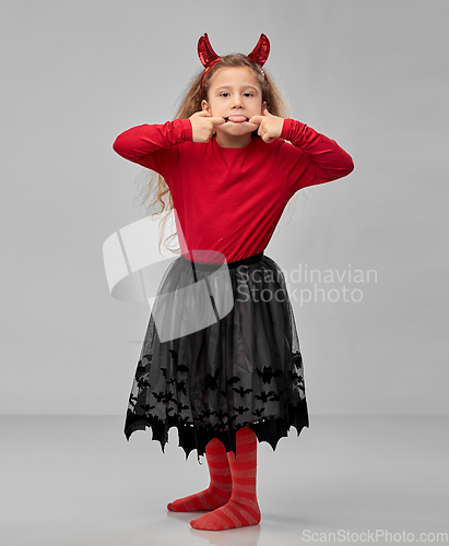 Image of girl in halloween devil's costume making faces