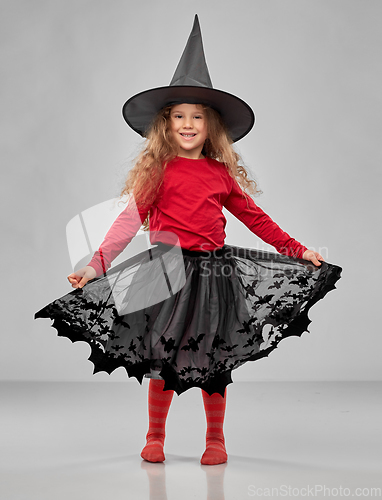 Image of happy girl in black witch hat on halloween