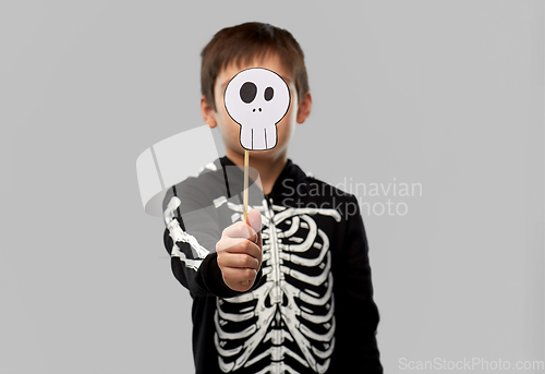 Image of boy in halloween costume with scull accessory