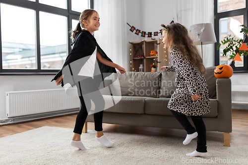 Image of girls in halloween costumes dancing at home