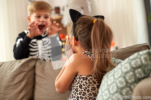 Image of kids in halloween costumes having fun at home