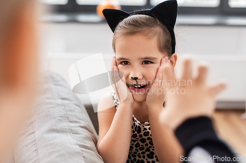 Image of kids in halloween costumes playing at home