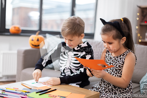 Image of kids in halloween costumes doing crafts at home