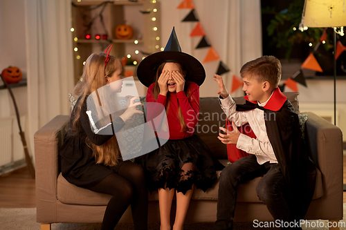 Image of kids in halloween costumes playing at home