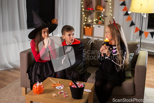 Image of kids in halloween costumes playing at home