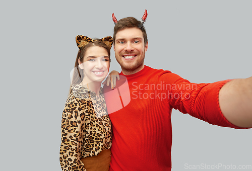 Image of happy couple in halloween costumes taking selfie